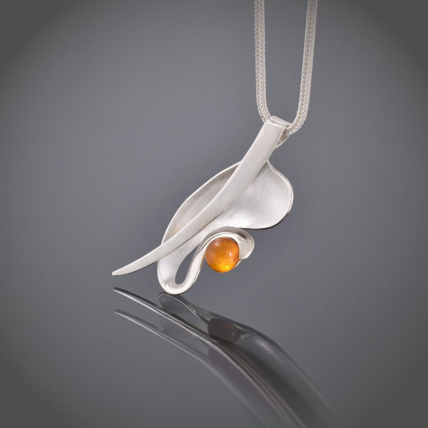 Right view of organic shaped silver pendant with amber cabochon on snake chain
