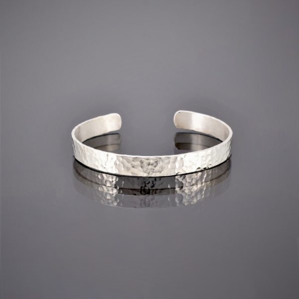 Flat view of a narrow hammered finish solid silver cuff