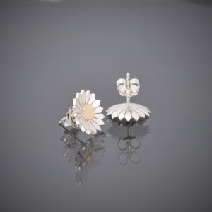 Upright view of a pair of brushed silver daisy stud earrings with a solid 18ct gold centre showing butterfly.