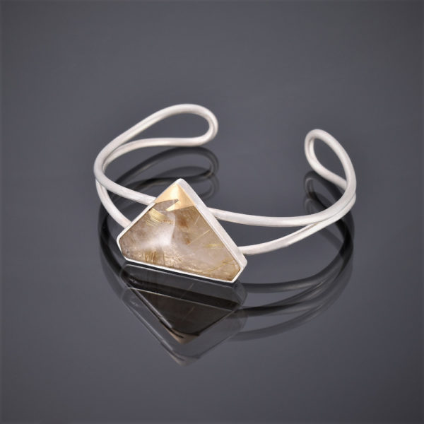 Right side view of a silver wire cuff with triangular rutilated quartz stone and 24ct gold detail