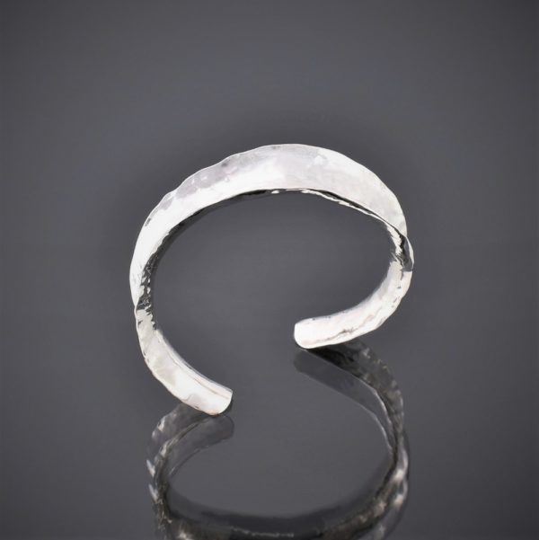 Top view of a hammered silver anticlastic cuff bracelet