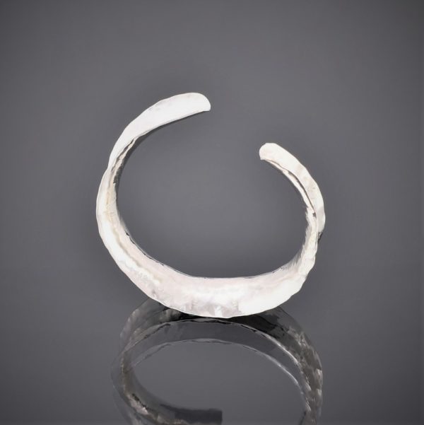 Upside down view of a hammered silver anticlastic cuff bracelet
