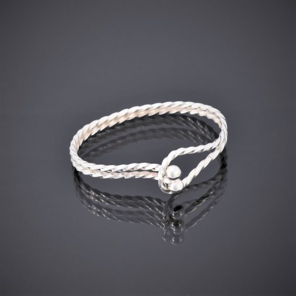 Horizontal view of a twisted solid silver square wire bangle with tension clasp