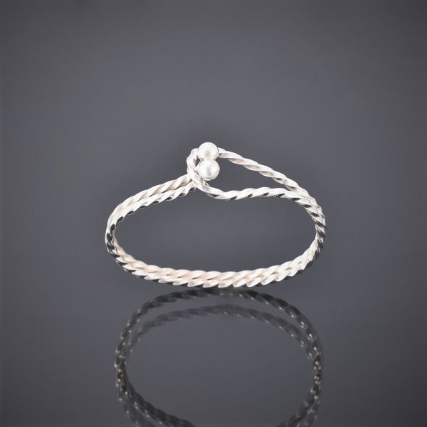 Upright side view of a twisted solid silver square wire bangle with tension clasp