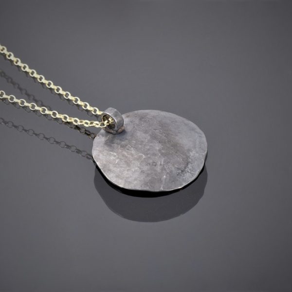 Back view of an oxidised and hammered 3 cm silver disk with keum boo on 18kt gold chain