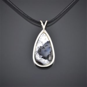 Front view of a large teardrop dendritic opal cabochon pendant set in round silver wire secured with a black leather cord