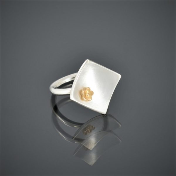 right view of a square brushed silver ring with 22ct rose mini flower. Round shank