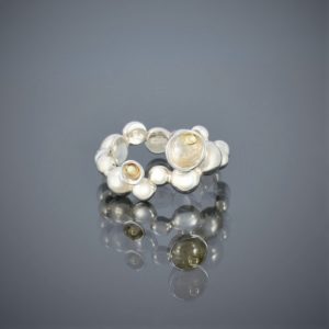 A ring made of solid silver beads of various sizes with gold bead detail