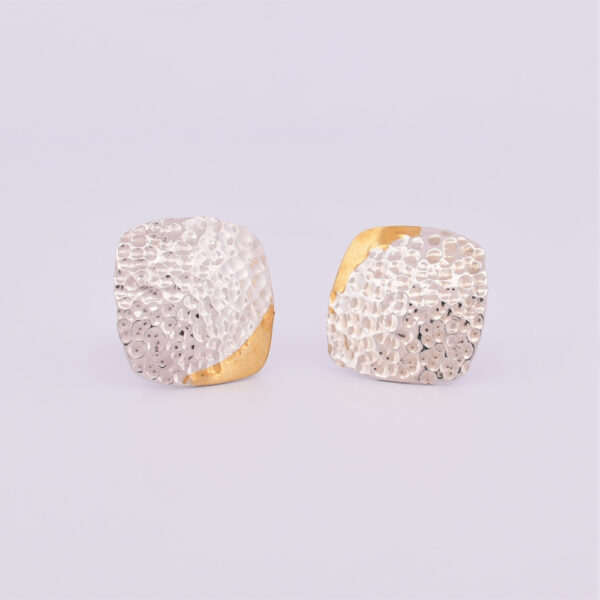 Front view of a pair of beaten silver stud earrings with a corner of keum boo detail