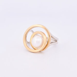 Left view of pearl set in a gold wire spiral and silver shank ring
