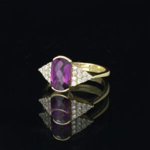 Side view of 18ct gold ring set with a faceted oblong rhodolite garnet and 20 pave set lab grown diamonds